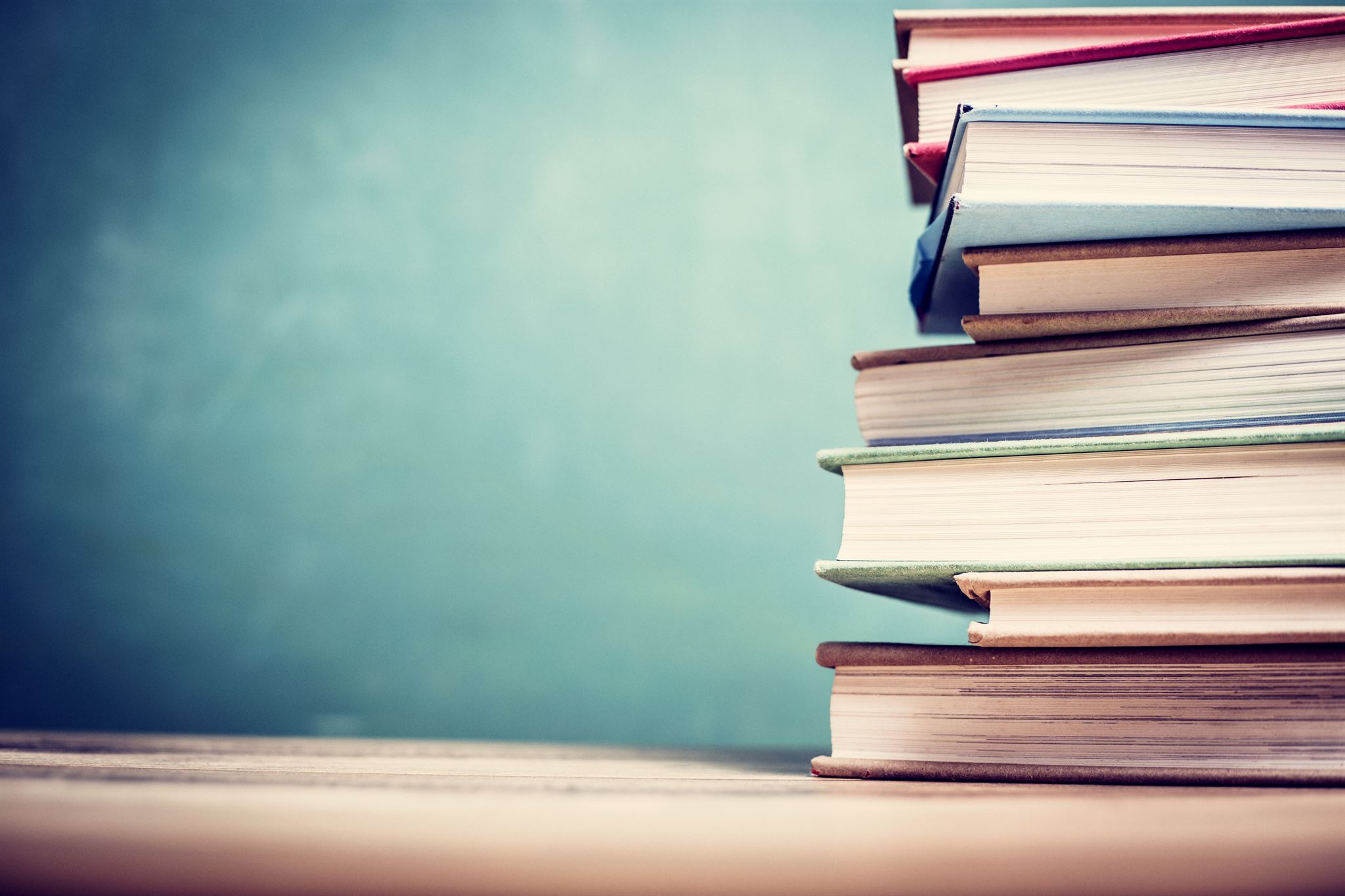 Books-stacked-on-a-wooden-table